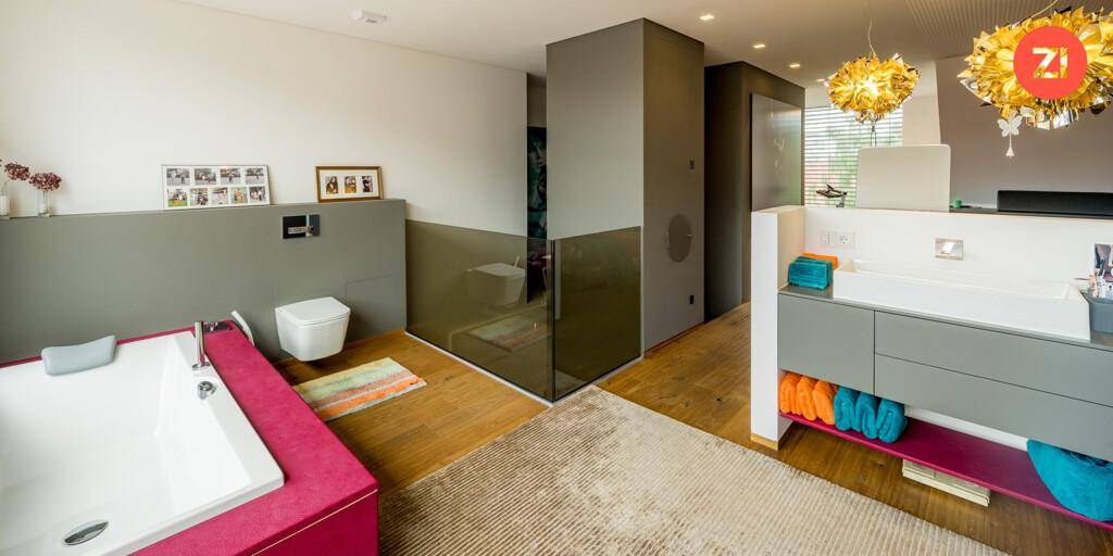 Helles Badezimmer mit Badewanne, Doppelwaschbecken und separater Glasdusche.