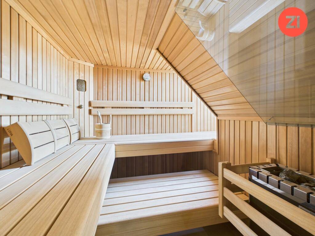 Geräumige Holzsauna mit bequemen Bänken und traditionellem Saunaofen.