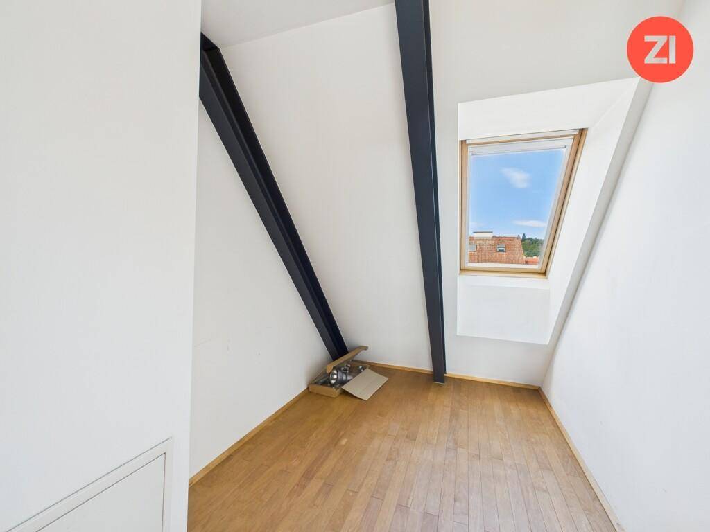 Kleiner Raum im Dachgeschoss mit Holzboden und Dachfenster.