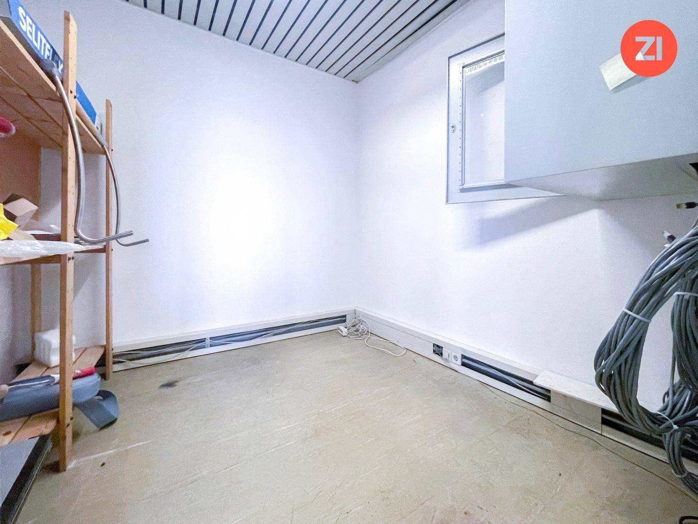 Abstellraum oder Technikraum mit Regalen, Kabeln und einem Fenster in der oberen Wand.