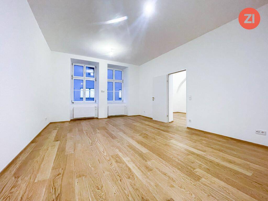 Geräumiges, helles Zimmer mit zwei großen Fenstern und neuem Holzboden.
