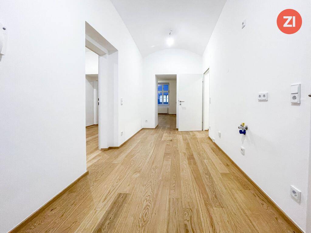 Langer, heller Flur mit Holzboden und Zugang zu verschiedenen Zimmern.