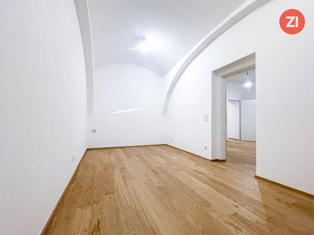 Geräumiges Zimmer mit gewölbter Decke und Holzboden, ideal für Wohn- oder Schlafbereich.