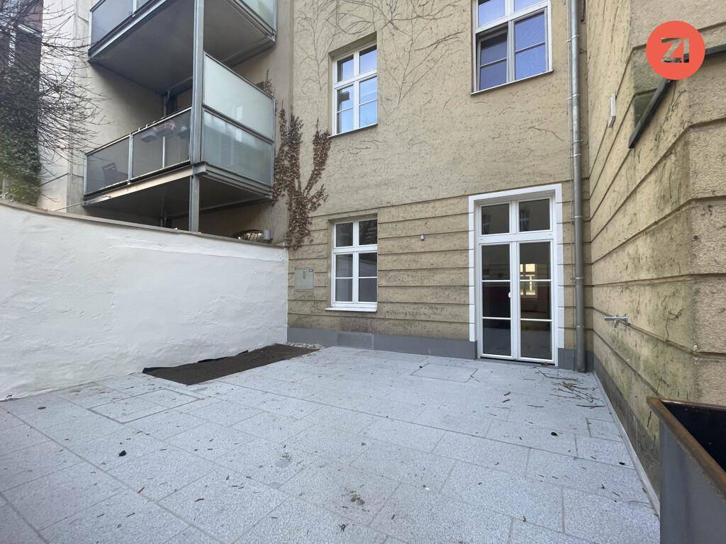 Kleine gepflasterte Terrasse im Hinterhof, ideal für entspannte Stunden im Freien.