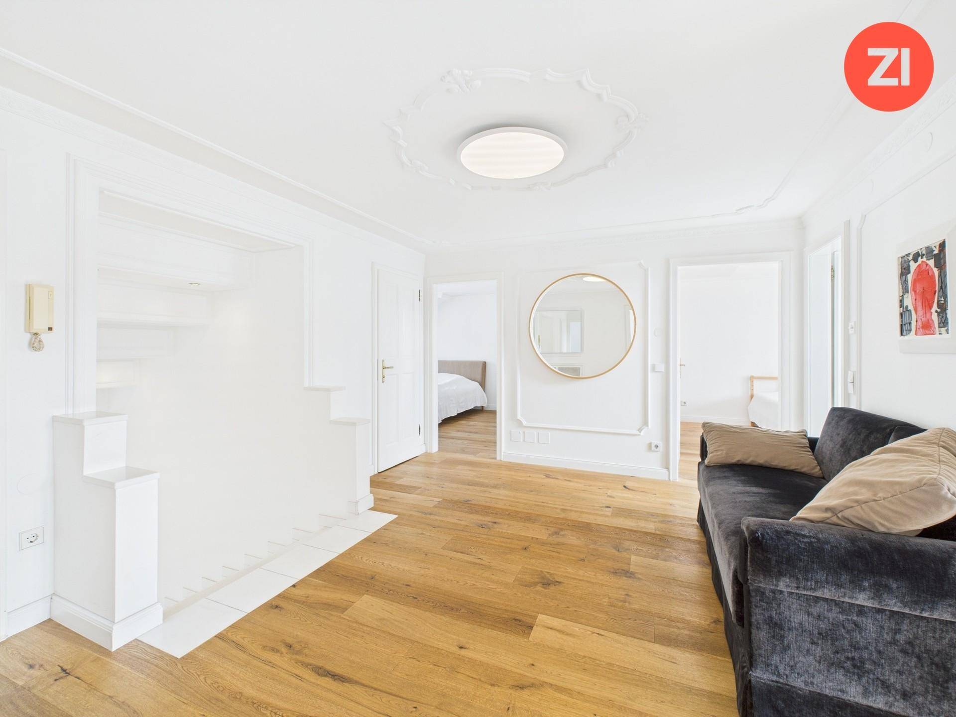 Eleganter Flur mit Holzboden, weiß gestrichenen Wänden und einer dekorativen Stuckdecke.