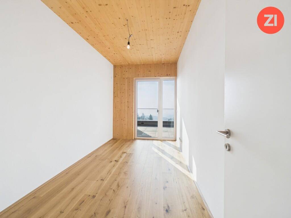 Lichtdurchflutetes Zimmer mit Holzboden und Holzdecke, ideal als Schlafzimmer mit Zugang zur Terrasse.