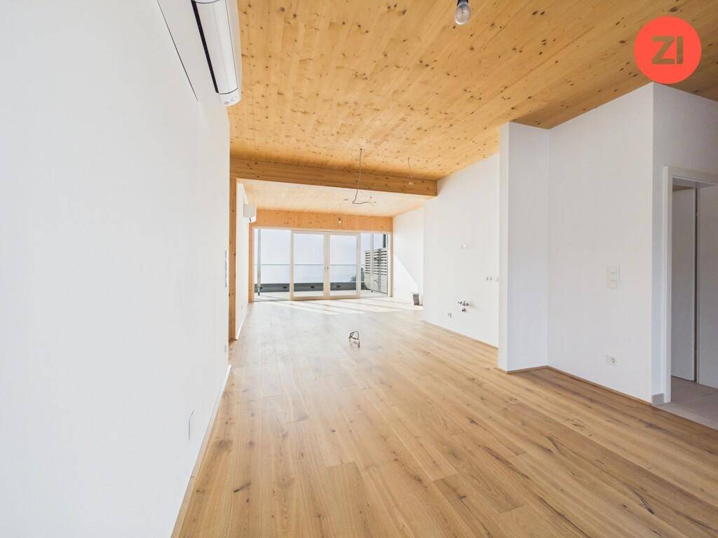 Geräumiger, heller Wohnbereich mit Holzboden, Holzdecke und Klimaanlage, bereit zum Einzug.