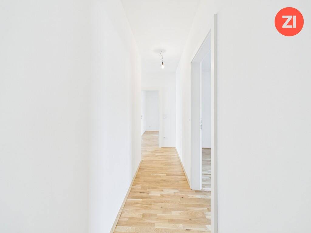 Heller Flur mit Parkettboden, der zu weiteren Räumen in der Wohnung führt.