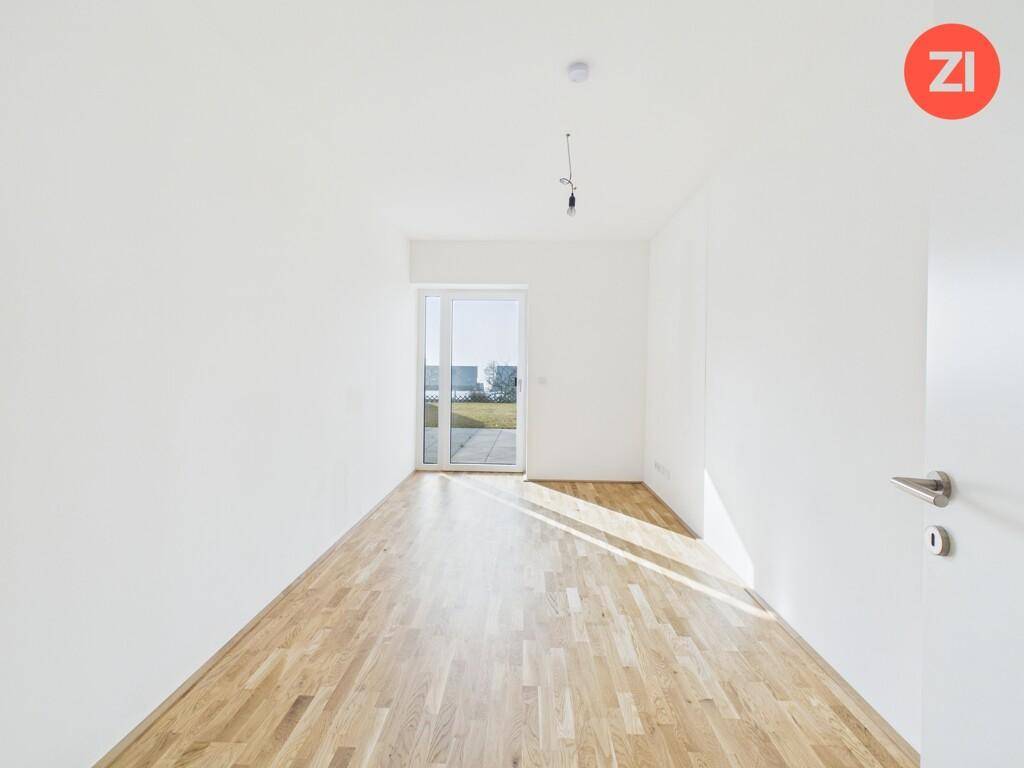 Freundliches Zimmer mit Parkettboden und Schiebetür zur Terrasse.