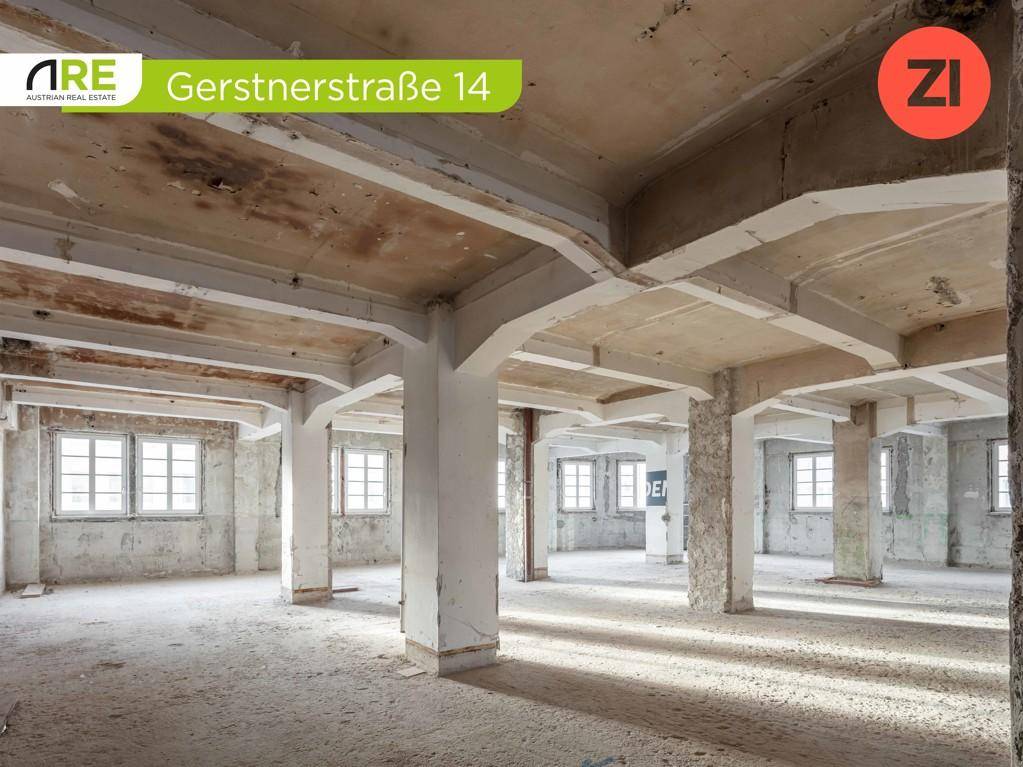 Großzügiger Innenraum mit sichtbaren Betonstrukturen, hohen Decken und viel Tageslicht durch Fenster.