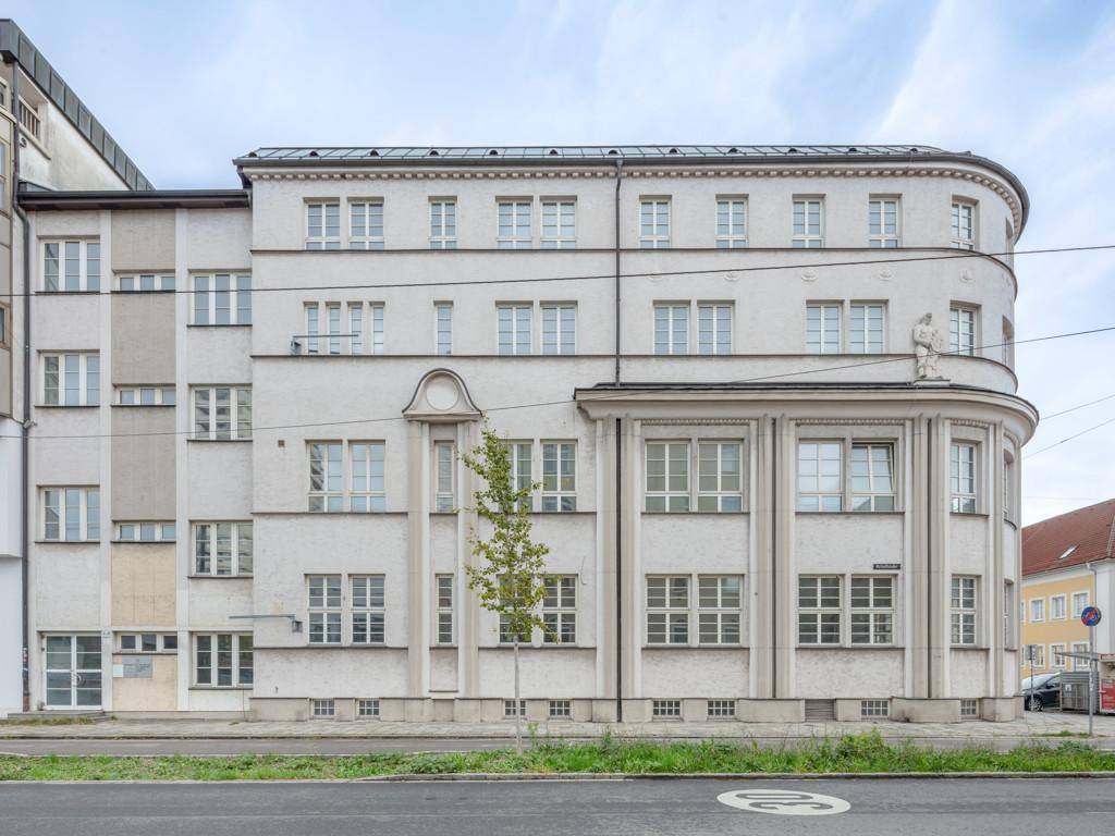 Ansicht der Gebäudefassade von der Straße aus mit vielen Fenstern und klassischer Architektur.