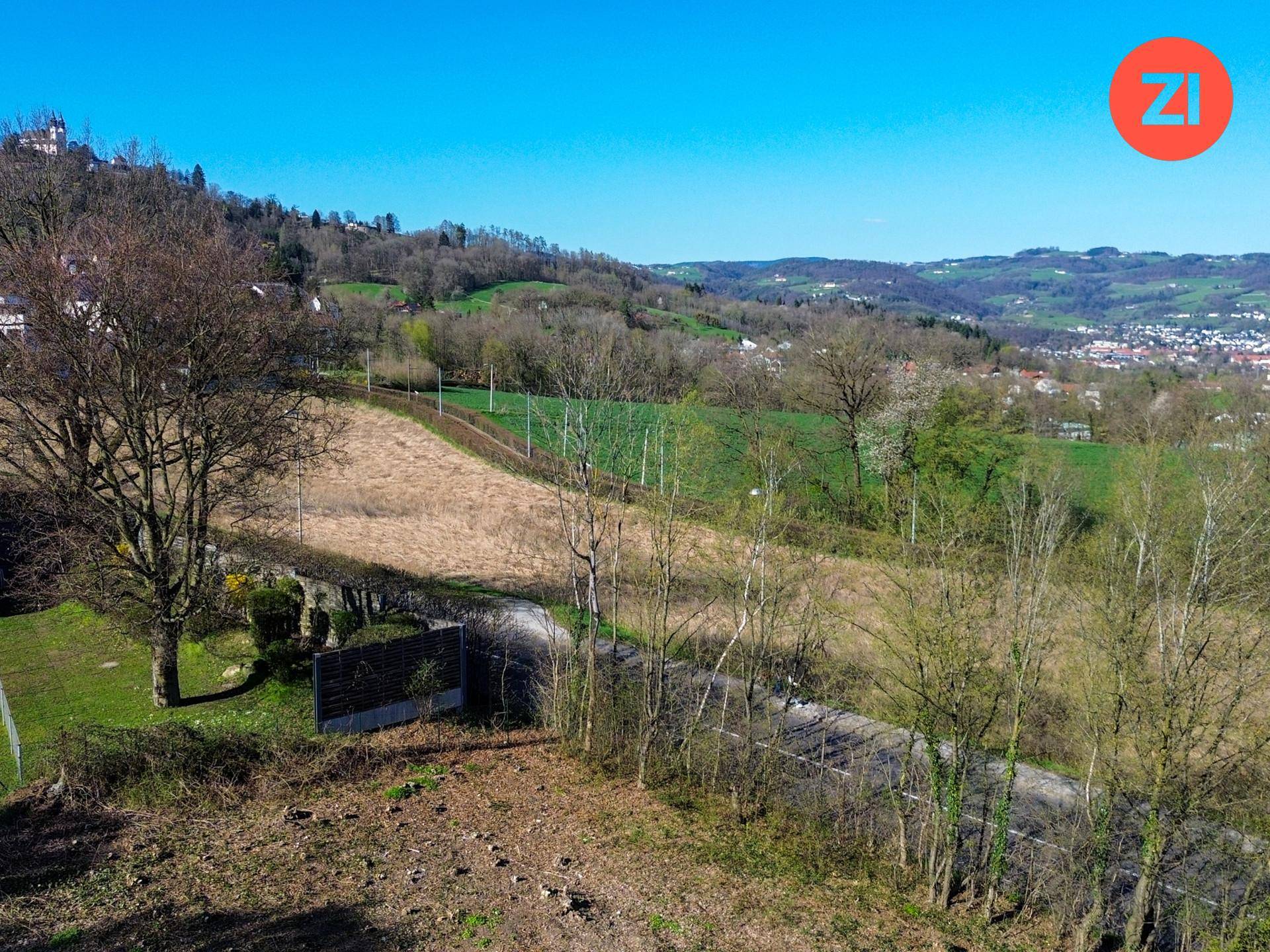 Weitläufige grüne Landschaft mit Hügeln und einem Blick auf die umliegende Natur.