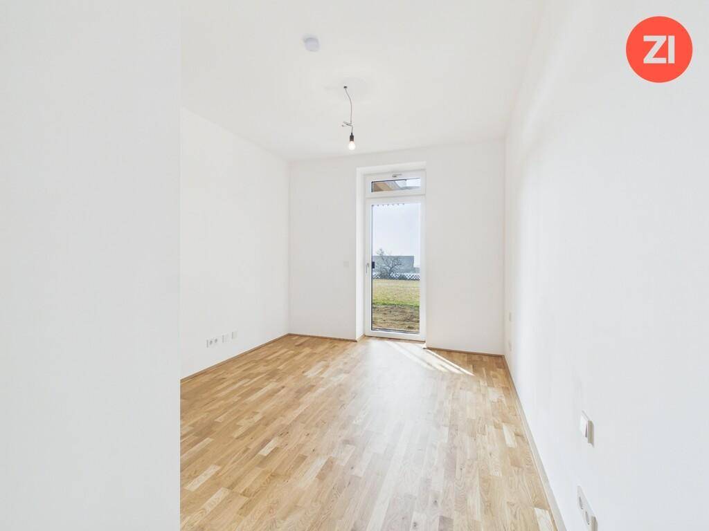 Helles Zimmer mit Parkettboden und direktem Zugang zum Gartenbereich.