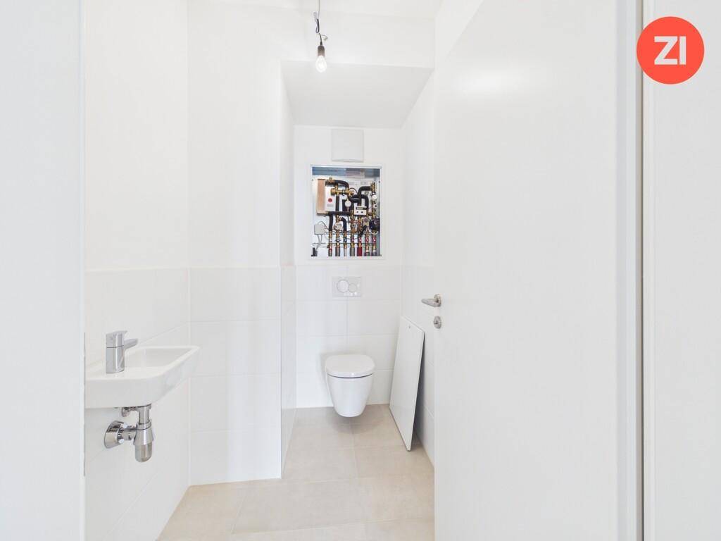 Kleines Gäste-WC mit wandhängendem WC und Handwaschbecken.