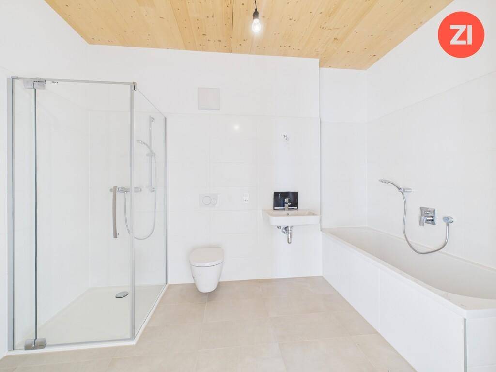 Modernes Badezimmer mit Badewanne, Duschkabine, WC und kleinem Waschbecken.