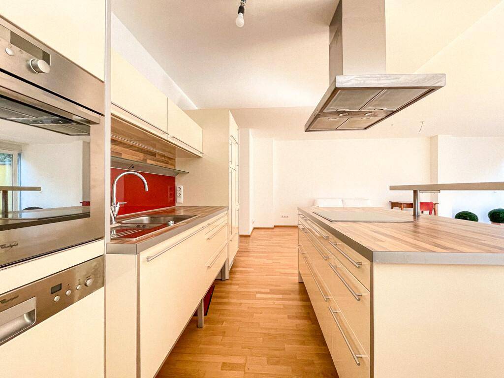 Moderne Einbauküche mit hochwertigen Geräten, Holz-Arbeitsplatten und einer praktischen Kücheninsel.