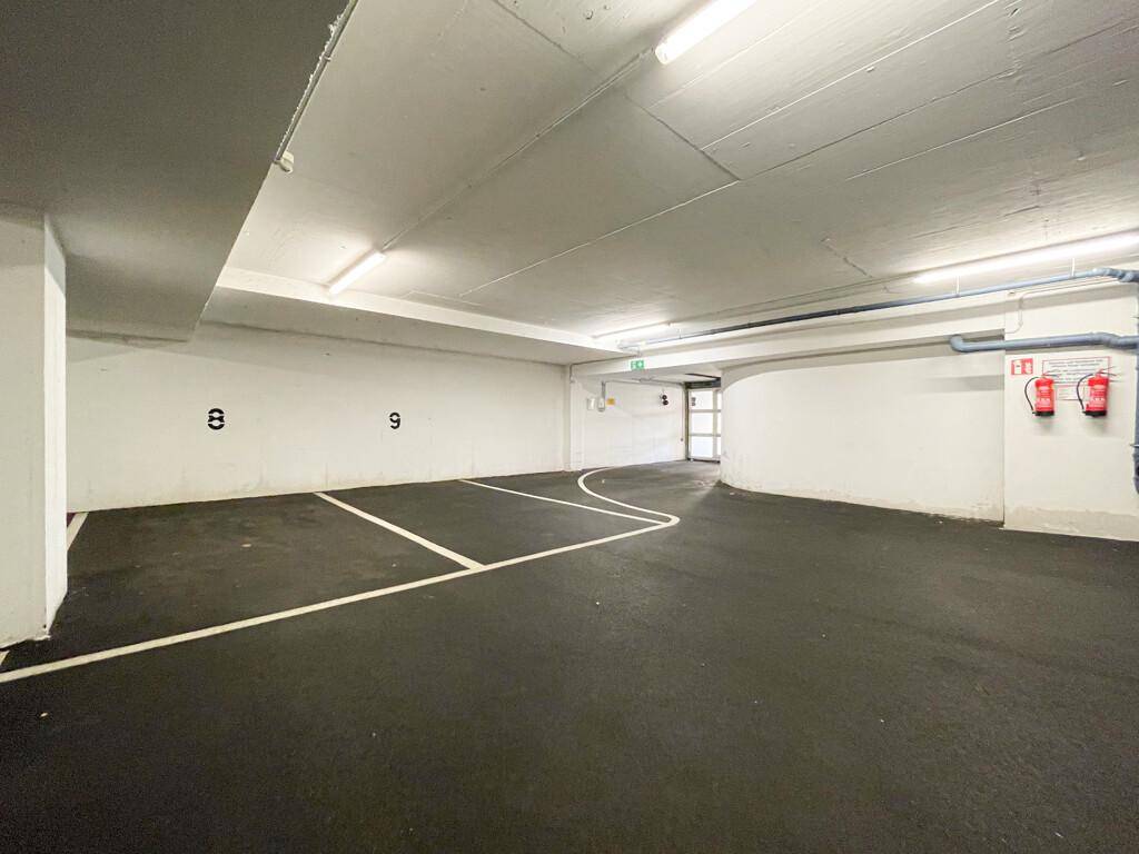 Tiefgarage mit markierten Stellplätzen und ausreichend Platz für mehrere Fahrzeuge.