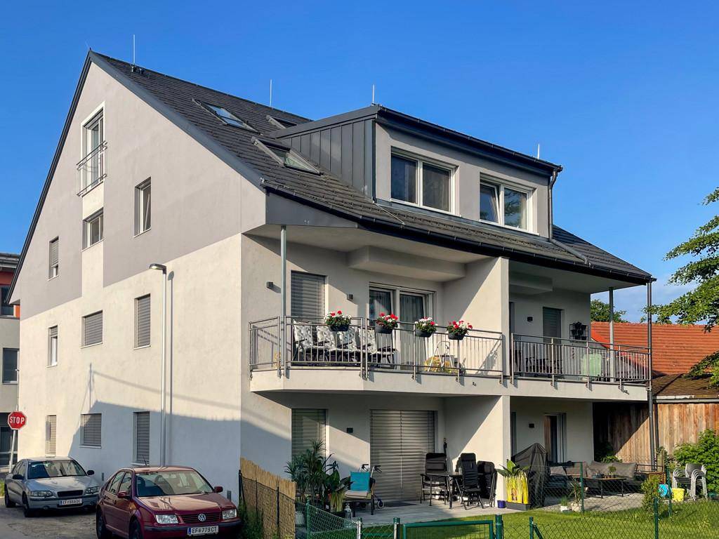 Modernes Mehrfamilienhaus mit Balkonen und Terrassen in einer ruhigen Wohngegend.