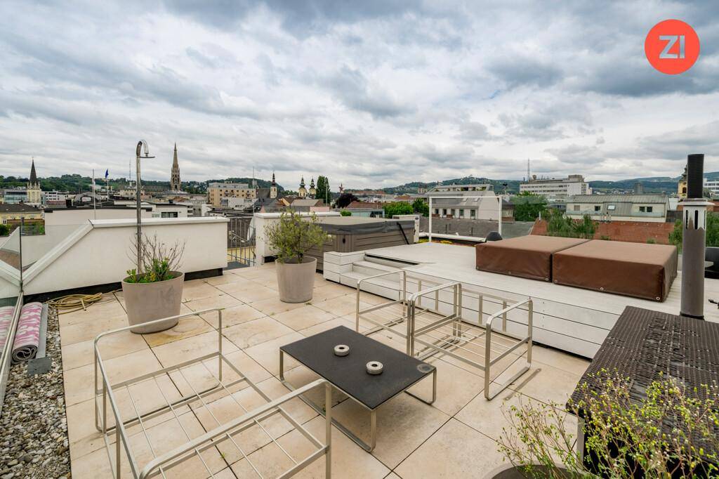 Große Dachterrasse mit Sitzgelegenheiten, Whirlpool und weitem Blick über die Stadt.