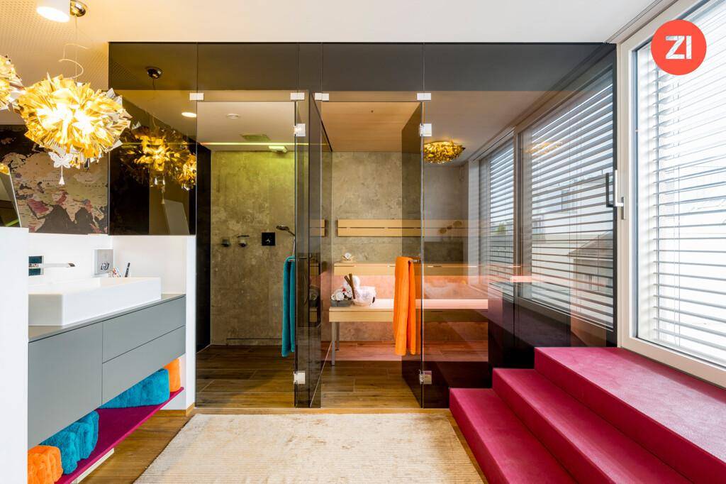 Modernes Badezimmer mit Glasdusche, Sauna und Doppelwaschbecken, hell und stilvoll gestaltet.