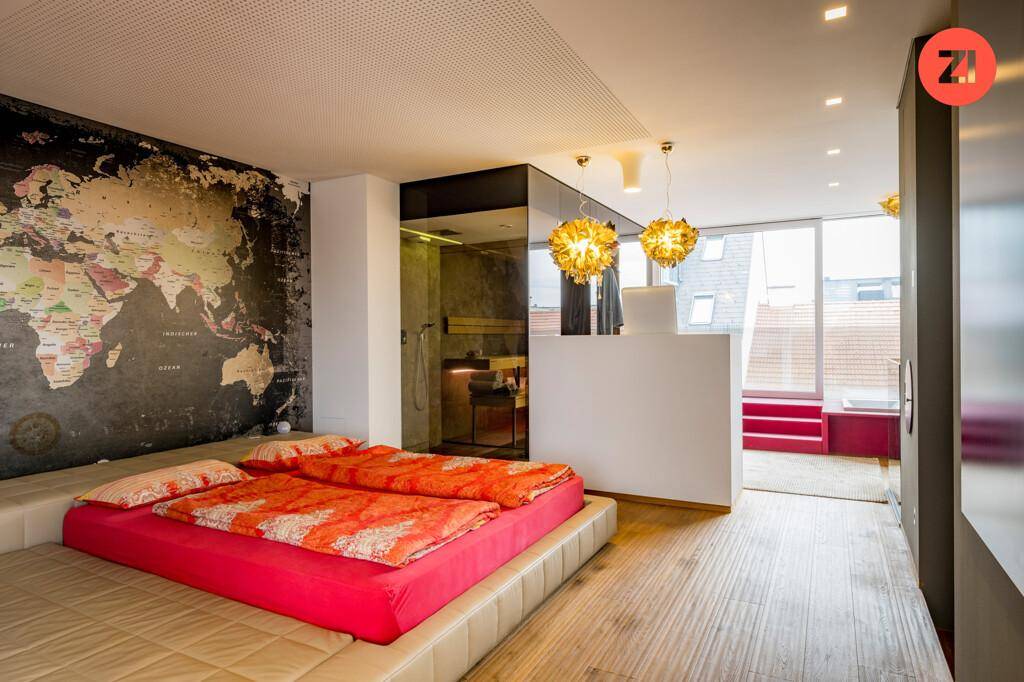 Modernes Schlafzimmer mit großer Weltkarten-Wandtapete, Holzboden und offenem Badbereich.