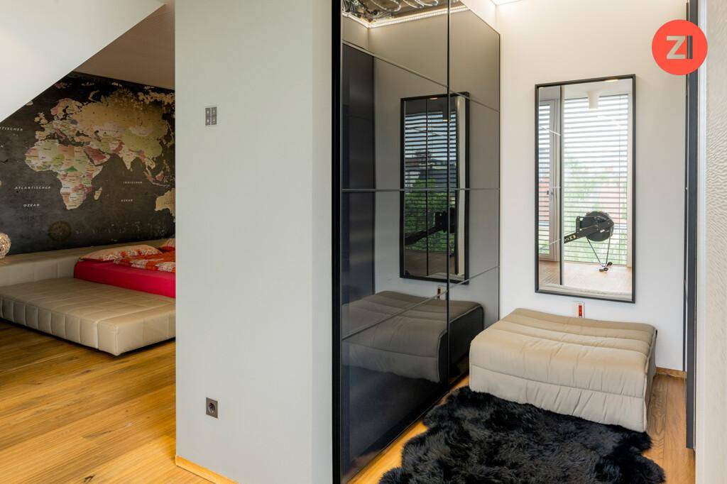 Schlafzimmerbereich mit Spiegelschränken, Holzboden und modernem Design.