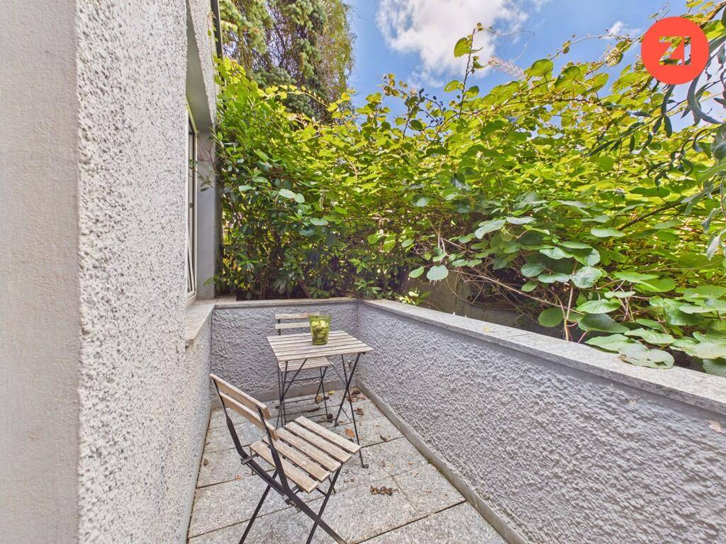 Kleiner, begrünter Balkon mit Sitzgelegenheiten, ideal für entspannte Stunden im Freien.
