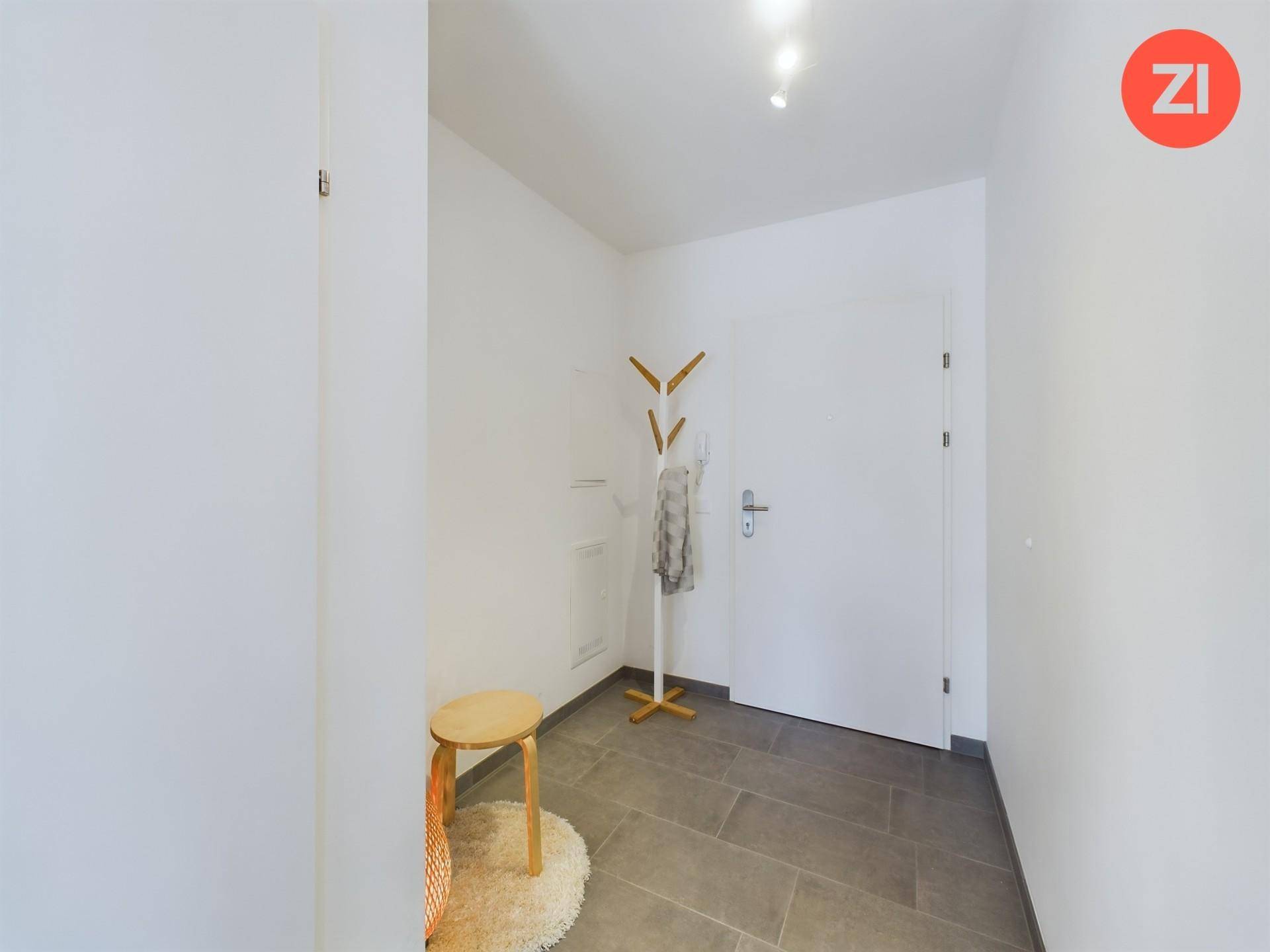 Heller Eingangsbereich mit Fliesenboden und Garderobe.