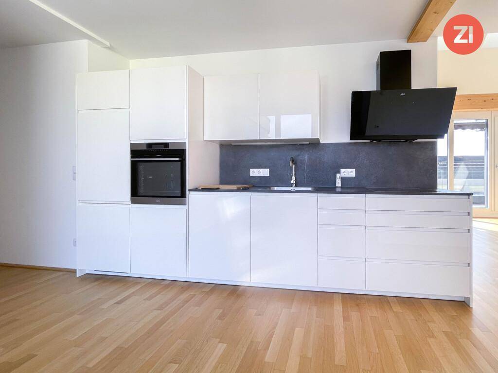 Detailansicht der modernen Einbauküche mit Backofen, Spüle und Dunstabzugshaube.