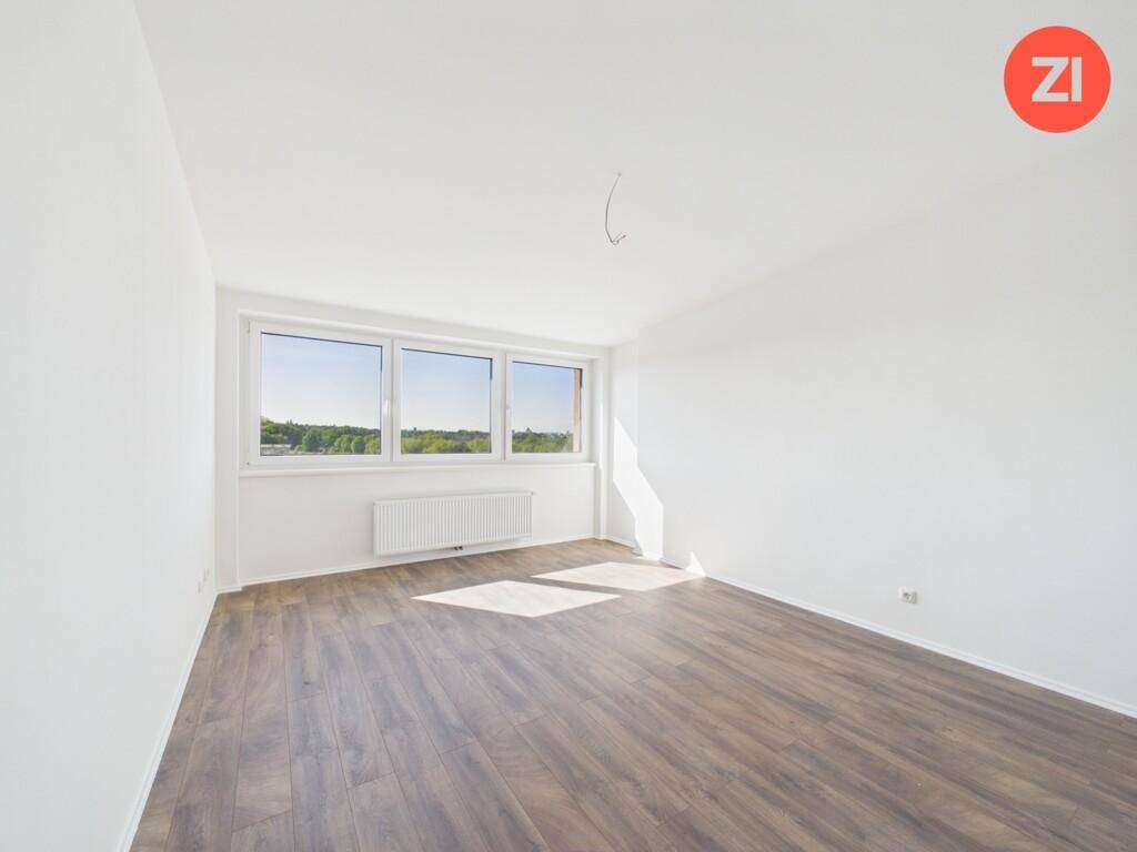 Geräumiges Schlafzimmer mit Laminatboden und großen Fenstern, die einen weiten Blick bieten.