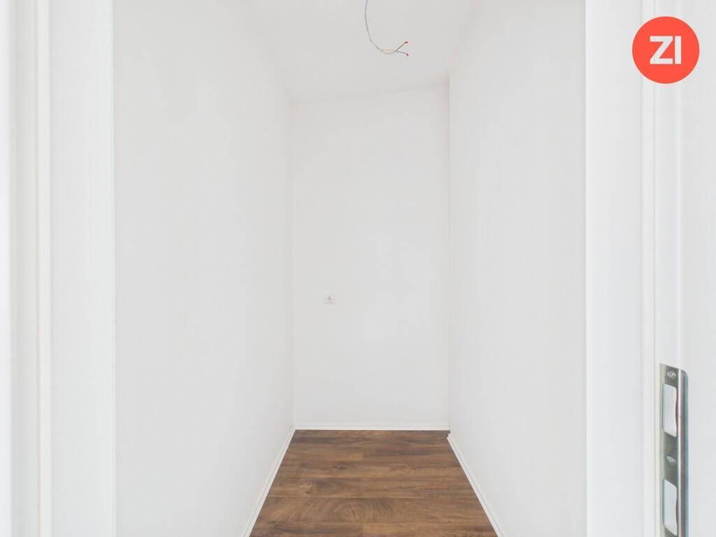 Schmaler, heller Flur mit Laminatboden, der verschiedene Bereiche der Wohnung verbindet.