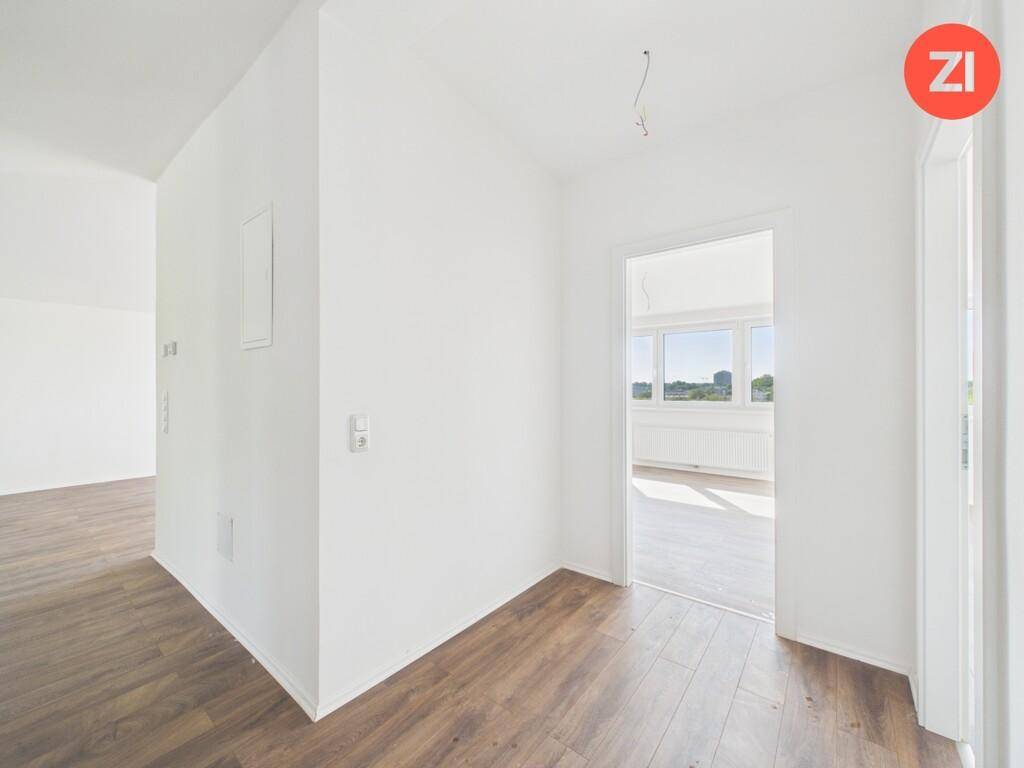Heller Flur mit Laminatboden und Zugang zu weiteren Räumen, der viel Potenzial bietet.