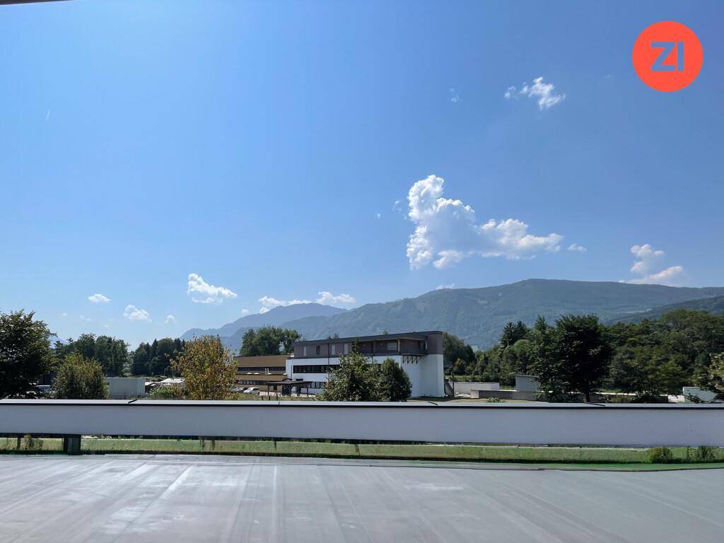 Weitblick auf grüne Berge und Landschaft unter einem klaren blauen Himmel.