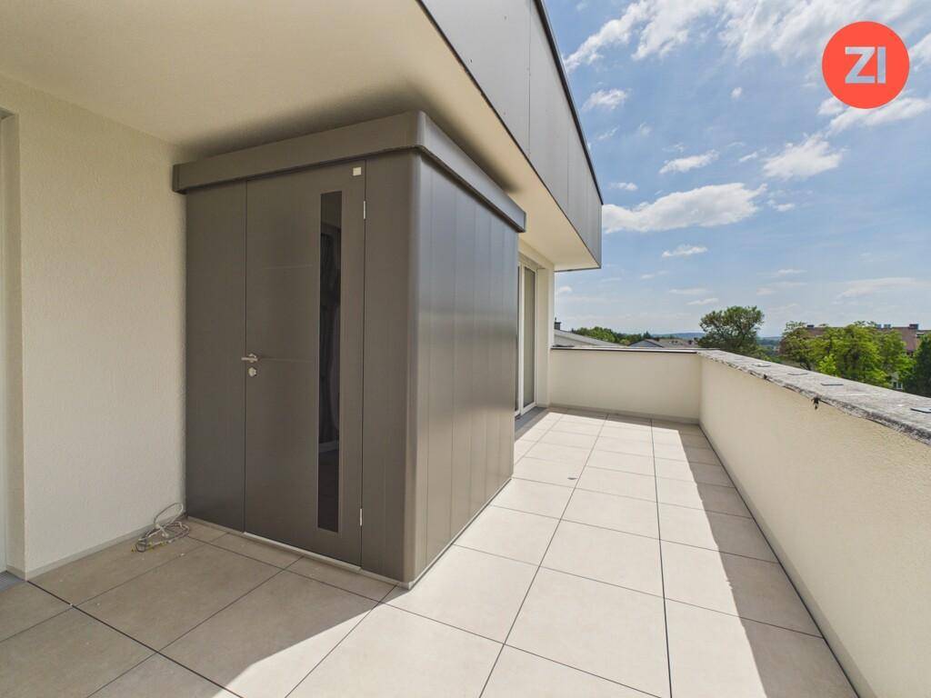 Heller Balkon mit praktischem Abstellschrank und weitem Blick in die Umgebung.