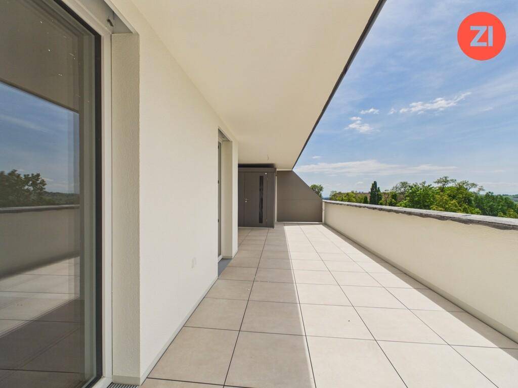 Langer, gefliester Balkon mit moderner Brüstung und weitem Blick in die Landschaft.