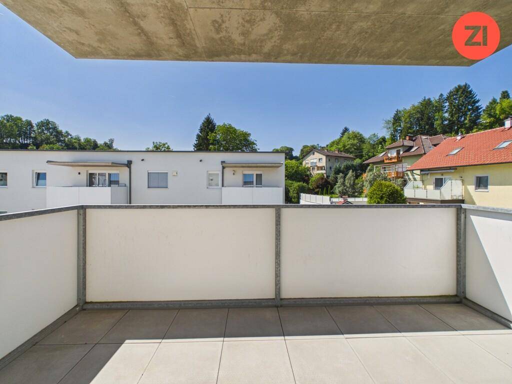 Geräumiger Balkon mit Fliesenboden und weitem Blick auf die grüne Umgebung.