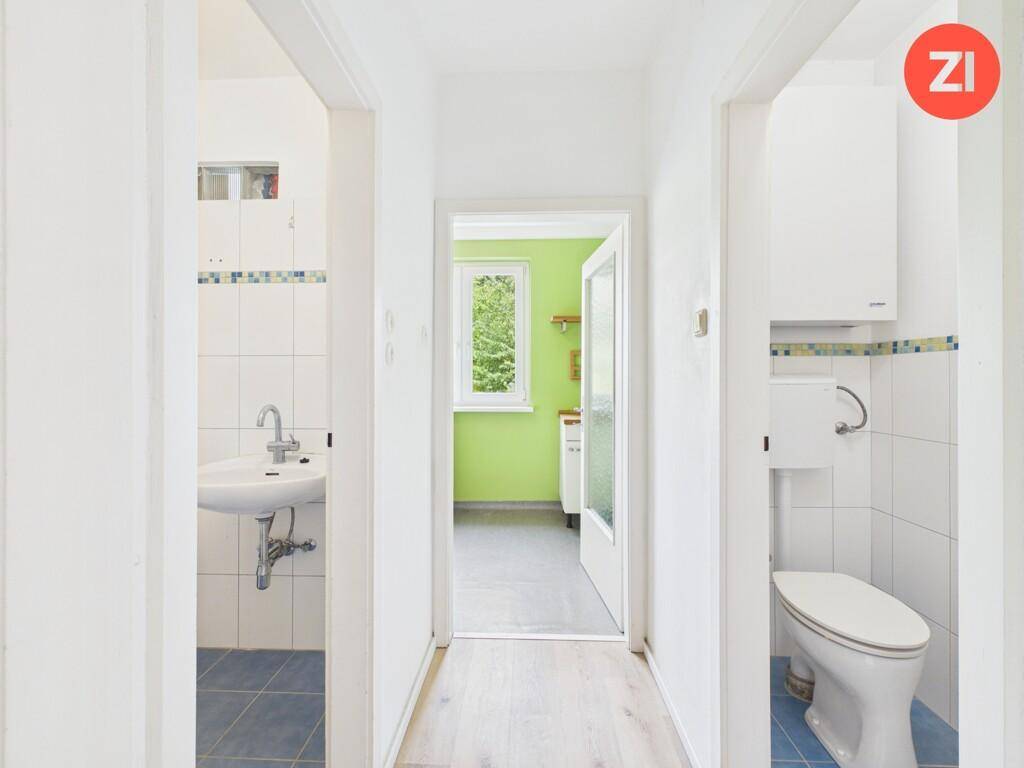 Heller Flur mit Zugang zu einem Badezimmer und einer separaten Toilette.