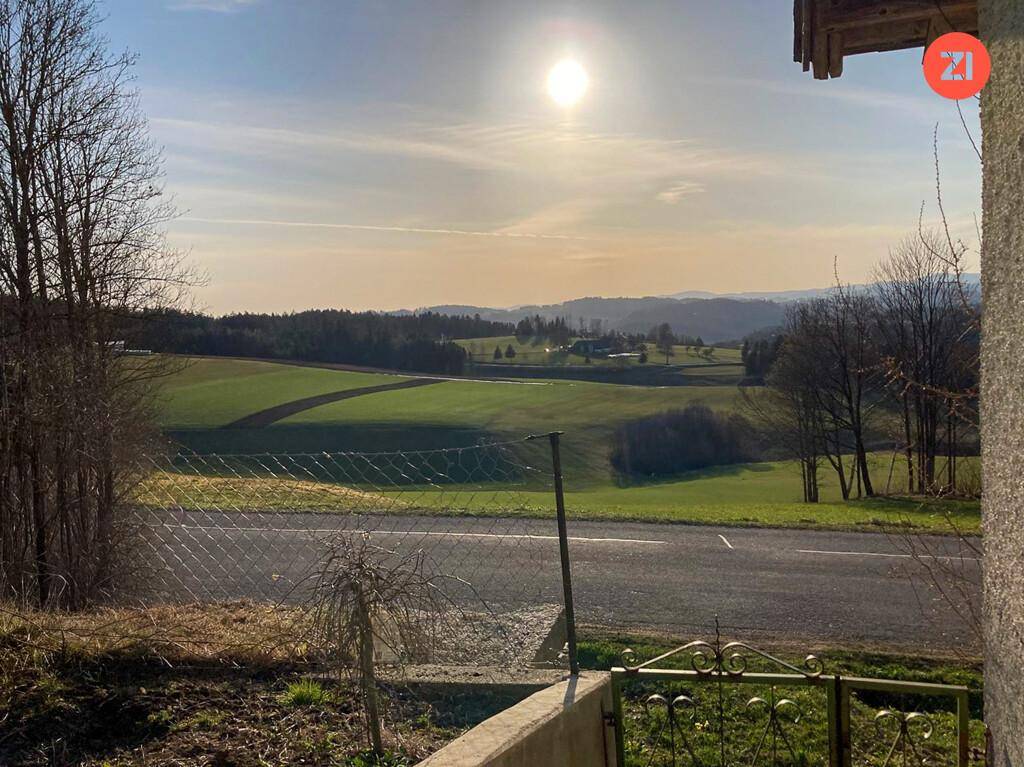 Sonniger Ausblick über weite Felder und sanfte Hügel in der ländlichen Umgebung.