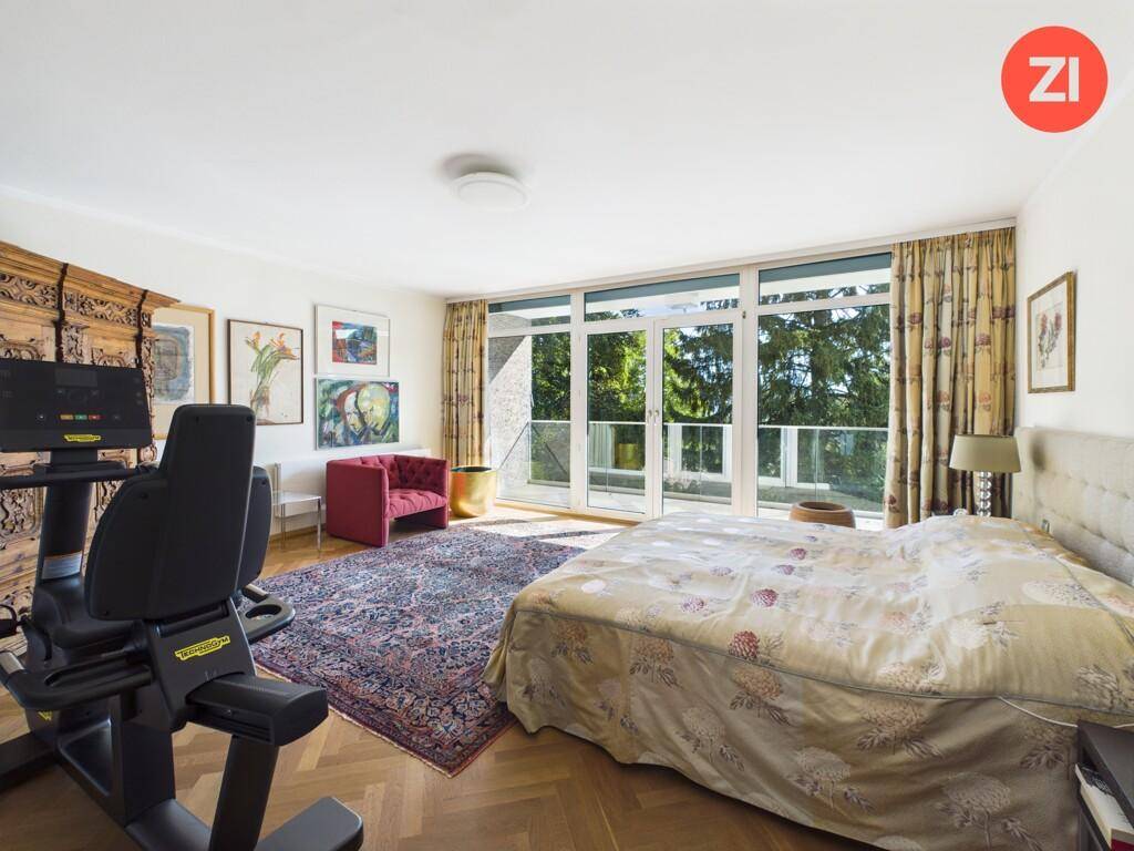 Geräumiges Schlafzimmer mit Doppelbett, Fitnessgerät und Zugang zum Balkon.
