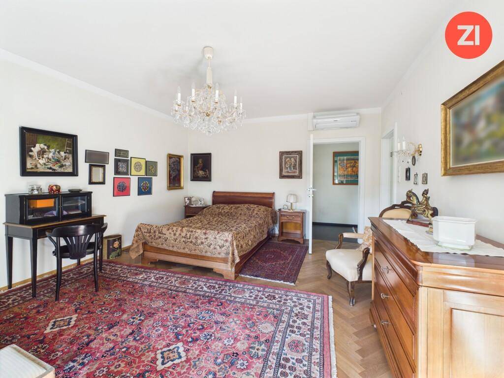 Geräumiges Schlafzimmer mit Doppelbett, Parkettboden und klassischer Einrichtung.