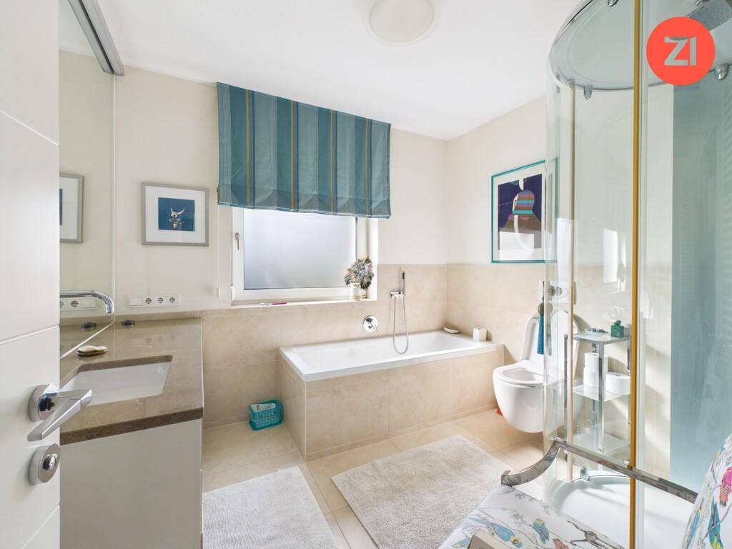 Modernes Badezimmer mit Badewanne, Duschkabine und Fenster.