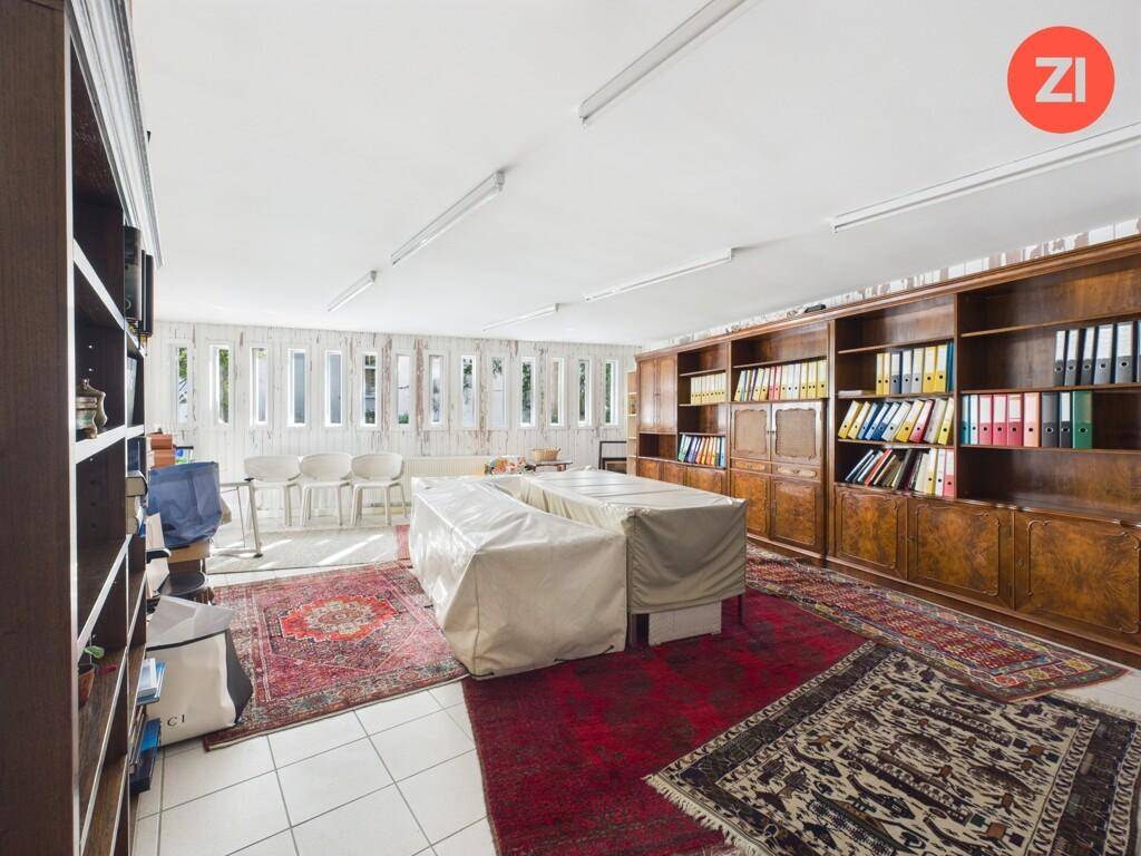 Großes Büro oder Arbeitszimmer mit Bücherregalen, Teppichen und viel Stauraum.