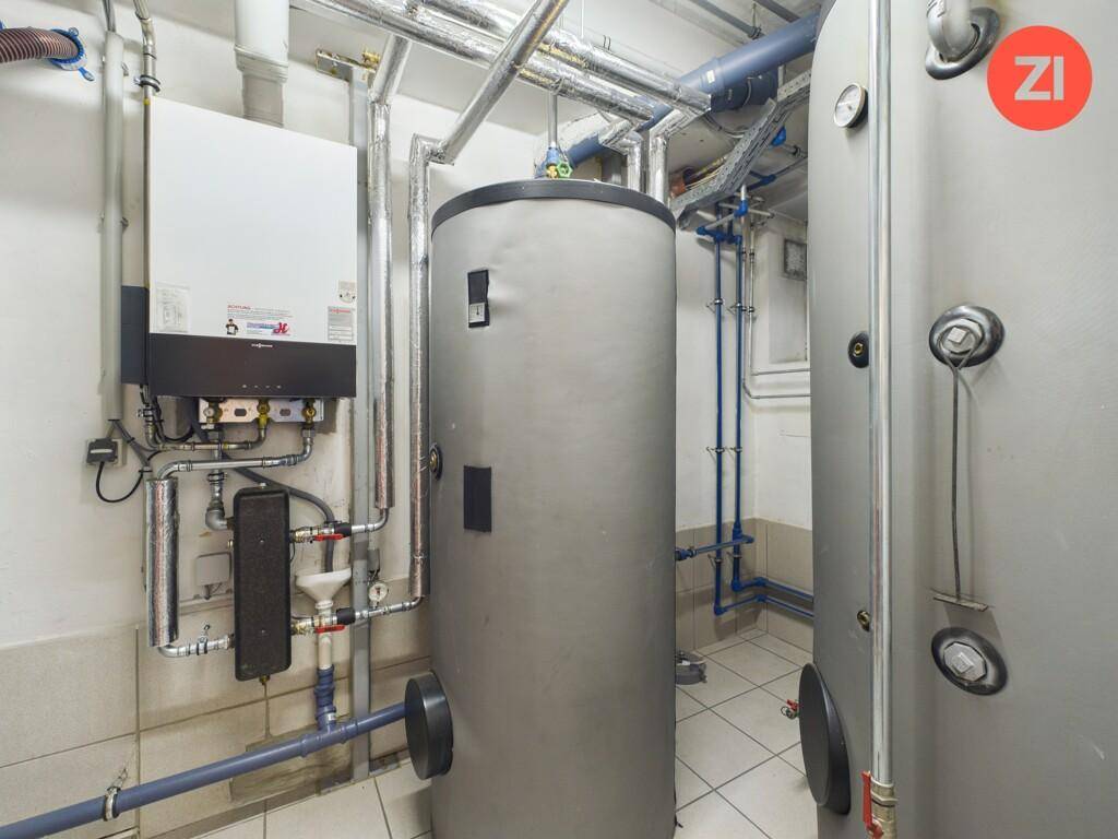Technikraum mit Warmwasserspeichern und komplexen Rohrinstallationen.