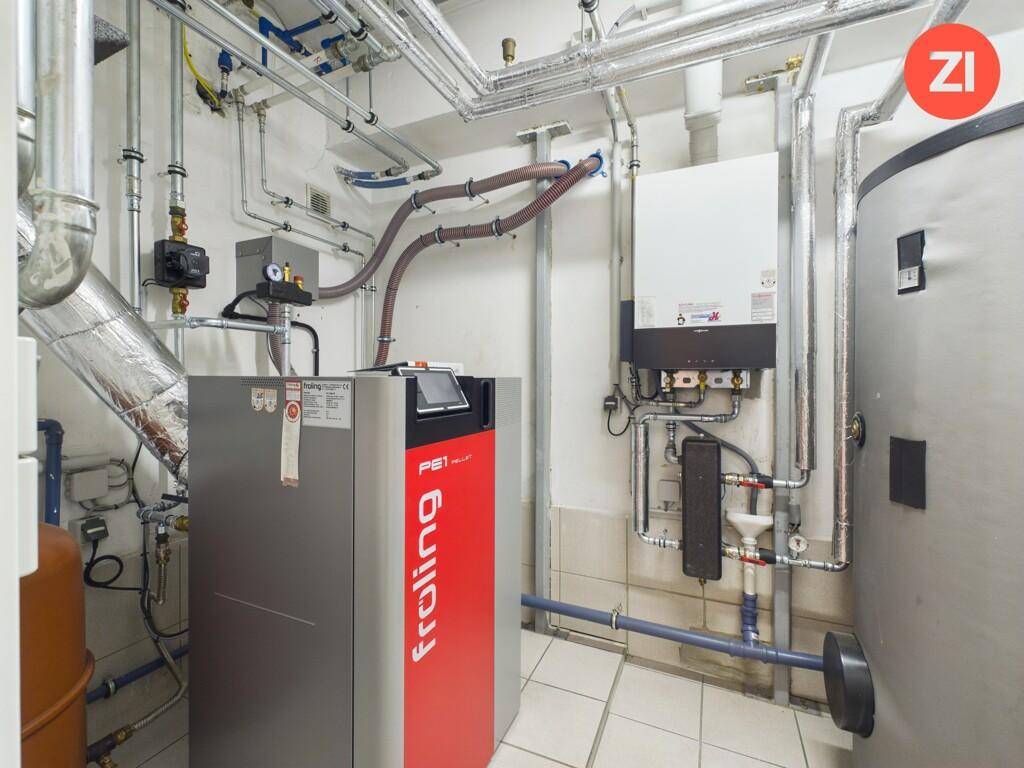 Heizungsraum mit moderner Pelletheizung und sichtbaren Rohrleitungen.