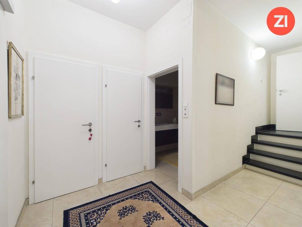 Eingangsbereich mit Fliesenboden, Treppe und Zugang zu einem weiteren Raum.