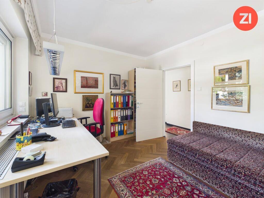 Funktionales Arbeitszimmer mit Schreibtisch, Regalen und Sofa.