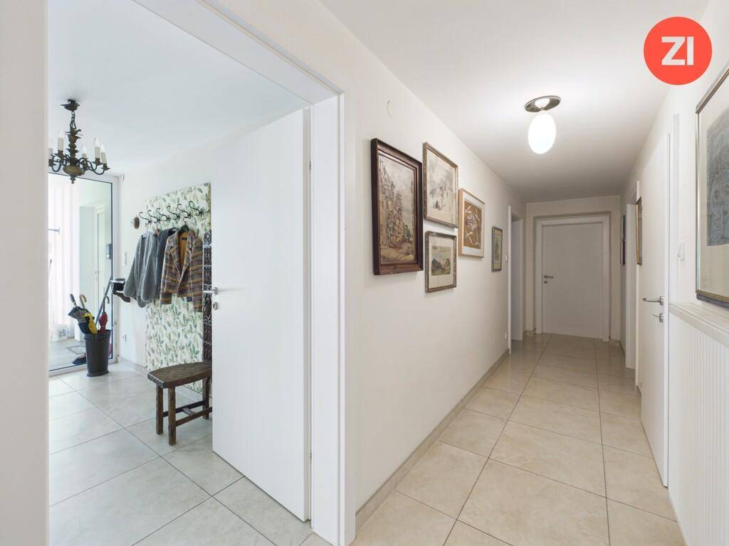 Heller Flur mit Fliesenboden, Garderobe und Zugang zu weiteren Räumen.