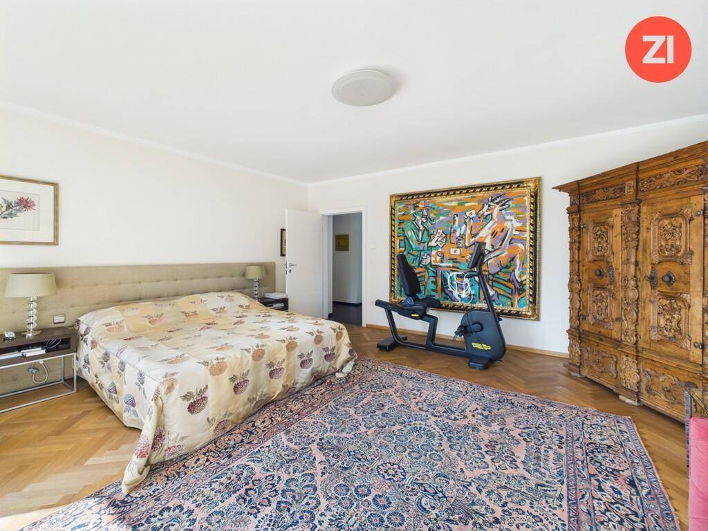 Geräumiges Schlafzimmer mit Parkettboden, großem Bett und traditionellem Holzschrank.