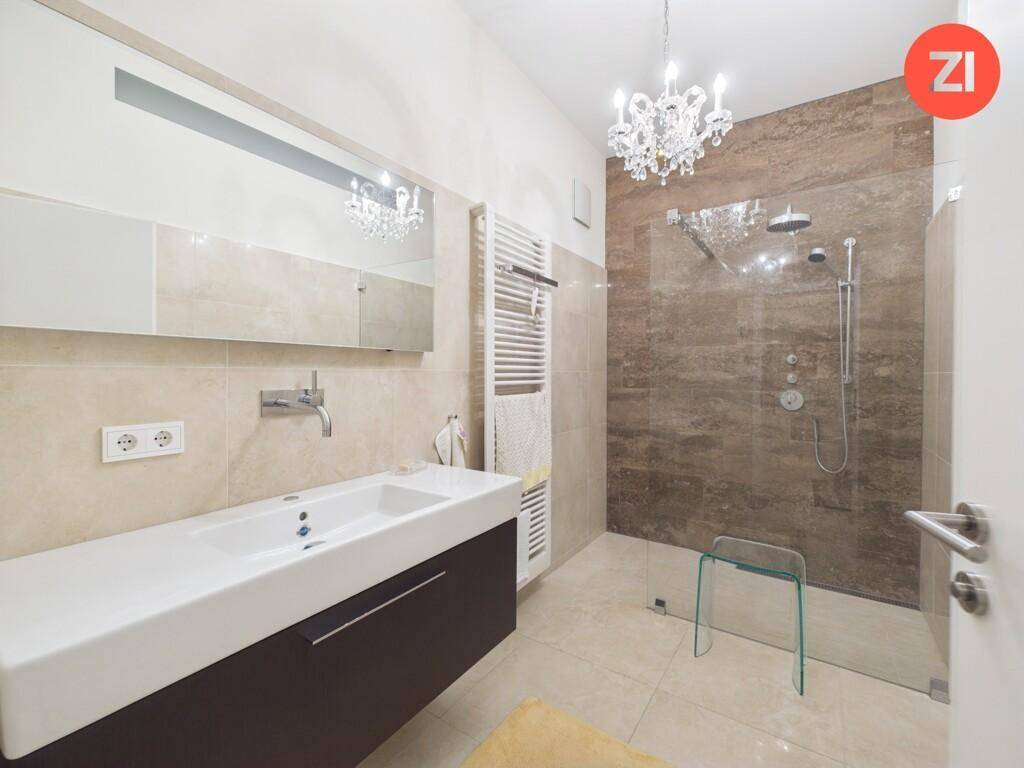 Modernes Badezimmer mit großer begehbarer Dusche, Einzelwaschbecken und Handtuchheizkörper.