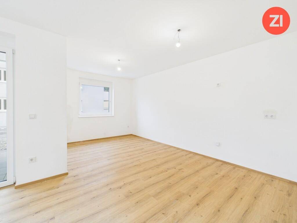 Geräumiger, heller Raum mit Laminatboden und einem Fenster, bereit zum Einrichten.